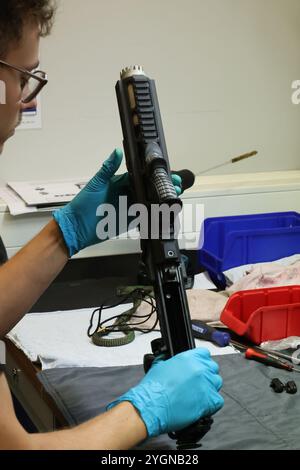 Erfurt, Deutschland. November 2024. Ein Mitarbeiter des Thüringer Landeskriminalamtes überprüft das neue Mittelstreckengewehr der Thüringer Polizei am Rande einer Pressekonferenz des Landeskriminalamtes. Über 1000 Gewehre des belgischen Herstellers FN Herstal wurden neu beschafft. Mittel-Entfernungswaffen werden von der Polizei eingesetzt, wenn es darum geht, entfernte Ziele zu treffen. Quelle: Bodo Schackow/dpa/Alamy Live News Stockfoto