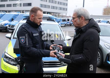 Erfurt, Deutschland. November 2024. Georg Maier (r, SPD), Innenminister Thüringens, übergibt auf einer Pressekonferenz des Landeskriminalamtes eine neue Mittelstreckenwaffe der Thüringer Polizei an Polizeisuperintendenten Alexander Albinus. Über 1000 neue Gewehre des belgischen Herstellers FN Herstal wurden beschafft. Mittel-Entfernungswaffen werden von der Polizei eingesetzt, wenn es darum geht, entfernte Ziele zu treffen. Quelle: Bodo Schackow/dpa/Alamy Live News Stockfoto