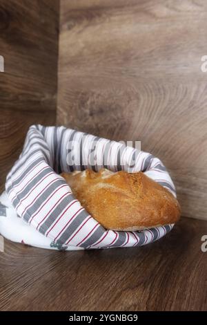 Brotlaib frisch gebackenes Brot in dekorativer bemalter Tasche aus Baumwolltextil, Nahaufnahme. Frühstückskonzept Stockfoto