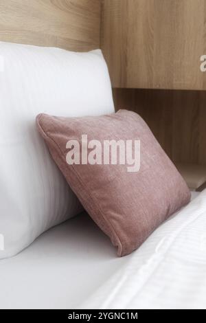 Komfortable weiche weiße und rosafarbene Kissen auf dem Bett, Unterkunft für Gäste bereit Stockfoto