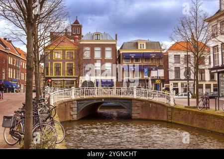 Haag, Niederlande, 6. April 2016: Blick auf die Straße mit traditionellen niederländischen Häusern neben einem Kanal in den Haag, Holland Stockfoto