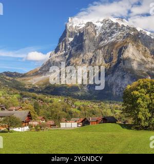 Grindelwald, Schweiz Antenne mit Blick auf das Dorf und Herbst Schweizer Alpen Panorama Landschaft, Holz- Chalets auf grünen Feldern und hohen Gipfeln in zurück Stockfoto