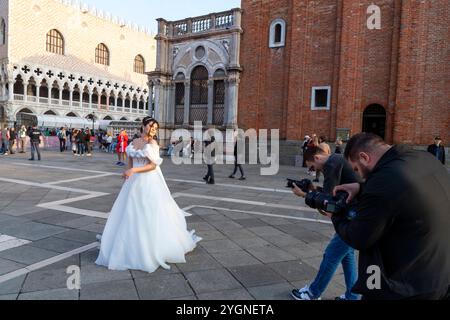Braut in weiß posiert für Fotografen auf dem Markusplatz in Venedig Stockfoto