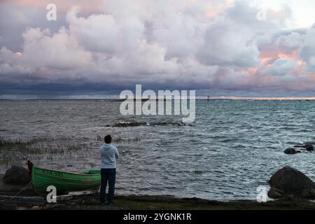 Einsamer Mann an der Ostseeküste während eines Sturms bei Sonnenuntergang Stockfoto