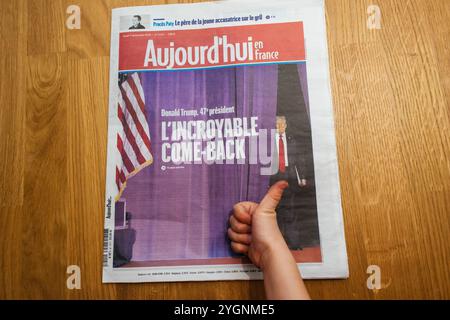 Paris, Frankreich - 7. November 2024: Der neugierige Kleinkinder zeigt die Titelseite von Aujourd'hui en France - Roady in Frankreich - mit Donald Trump Comeback-Schlagzeile, die frühes Interesse an den Ereignissen der Welt zeigt Stockfoto