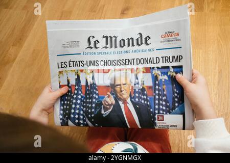 Paris, Frankreich - 7. November 2024: Ein Kind hält eine Kopie von Le Monde mit einer Titelgeschichte über den Wahlsieg Donald Trump in den USA, die die französische Perspektive auf das Ereignis zeigt Stockfoto