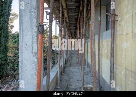 Ein durch Metallgerüste gestützter Baustellenflur, der den Rohbeton und die unfertigen Oberflächen zeigt. Stockfoto