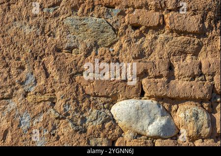 Alte Ziegelmauer mit Lehm Sand und Kalk verputzt, vom Regen gewaschen Stockfoto