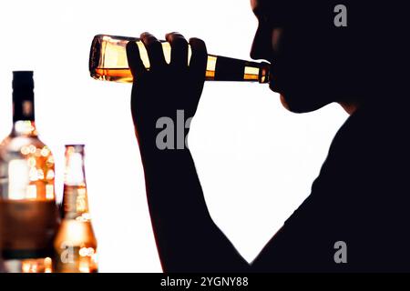 Alkoholsüchtig. Alkoholproblem und Missbrauch. Silhouette eines Mannes mit Bier. Alkoholkonsum. Reha, Entgiftung oder Erholung. Weinflasche auf dem Tisch. Stockfoto