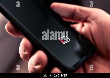 Akku des Telefons mit niedriger Ladung. Handy ohne Strom. Energieabfluss. Leeres und leeres Smartphone. Symbol für die Lebensdauer des mobilen Ladegeräts auf dem Bildschirm. Stockfoto