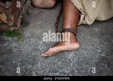 Detail der geketteten Füße einer schwarzen Frau in Pelourinho. Sklaverei in Brasilien. Darstellung der Sklavin Anastacia. Stockfoto