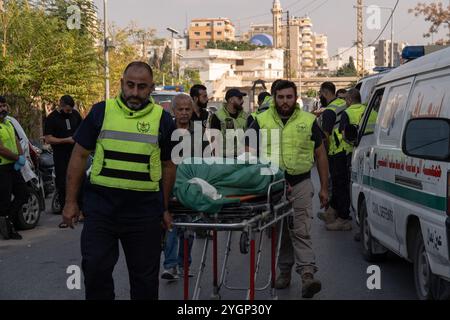 Reifen, Libanon. November 2024. Rettungssanitäter werden am 7. November 2024 in Tyrus, Libanon, gesehen, wie sie die Leichen neben einem Krankenwagen herumrollten. Mindestens 30 Menschen starben, nachdem Israel ein gezieltes Gebäude in Barja angegriffen hatte, einem überwiegend sunnitischen Gebiet, in dem Vertriebene aus dem Süden untergebracht sind. Spekulationen über zunehmende sektiererische Spannungen, während israelische Streitkräfte gezielt gegen nicht traditionelle Hisbollah-Gebiete streiken. Quelle: SOPA Images Limited/Alamy Live News Stockfoto