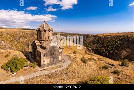 Blick von der Drohne auf die Flagge von Armenien und die berühmte Vahramashen-Kirche aus dem 11. Jahrhundert, in der Nähe der Festung Amberd an sonnigen Sommertagen. Klippe mit Arkashian Stockfoto