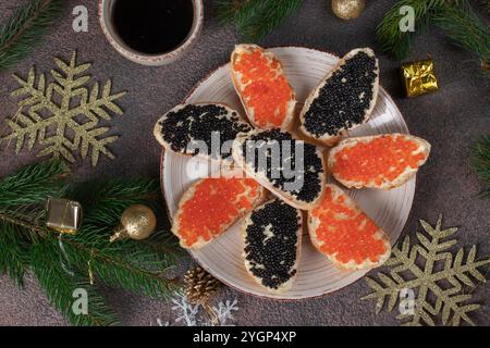 Hausgemachte Sandwiches mit rotem und schwarzem Kaviar auf weißem Brot Toast auf runder Platte auf braunem Hintergrund, Blick von oben Stockfoto