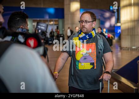 Lod, Israel. November 2024. In der Ankunftshalle des Flughafens Ben Gurion wird ein Fan von Maccabi Tel Aviv gesehen. Israelische Fußballfans wurden vor dem Fußballspiel der UEFA Europa League zwischen Ajax Amsterdam und Maccabi Tel Aviv am Donnerstag von pro-palästinensischen Demonstranten angegriffen. Quelle: Ilia Yefimovich/dpa/Alamy Live News Stockfoto