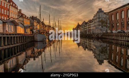 Sonnenaufgang am Ende des Nyhavn-Kanals in Kopenhagen mit Reflexionen im ruhigen Wasser, Dänemark, 2. November 2024 Stockfoto