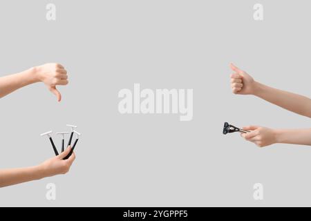Weibliche Hände mit Rasiermesser mit Daumen-nach-oben- und nach-unten-Gesten auf grauem Hintergrund Stockfoto