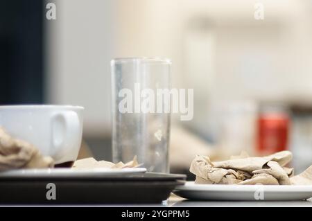 Viladecans. Spanien - 8. November 2024: Eine geschäftige Cafeteria mit Tischen, die mit Resten von Geschirr und Tassen verstreut sind, was auf einen kürzlich abgeschlossenen Speiseeis hindeutet. Stockfoto