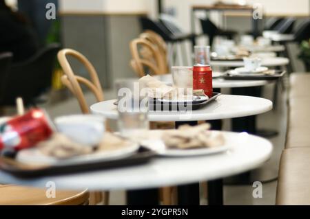 Viladecans. Spanien - 8. November 2024: Die Ruhe des Nachmittags in einem geschäftigen Café mit leeren Tischen und übrig gebliebenen Tassen. Das Bild erfasst die ess Stockfoto