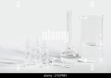 Medizinische Ampullen mit Laborglas auf grauem Hintergrund Stockfoto