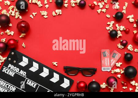 Komposition mit Filmklatscher, 3D-Brille, verstreutem Popcorn, Kinokarten und Weihnachtsdekoration auf rotem Hintergrund. Draufsicht Stockfoto