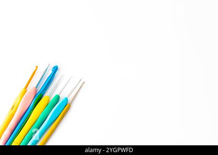 Helle Häkelhaken verschiedener Größe isoliert auf weißem Hintergrund. Farbige Häkelnadeln. Kopierbereich, Draufsicht, flache Ladefläche. Konzept der Strickidee. Leer. Stockfoto