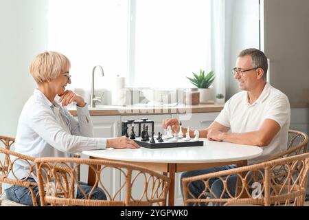 Seniorenpaar, das zu Hause gemeinsam Schach spielt Stockfoto