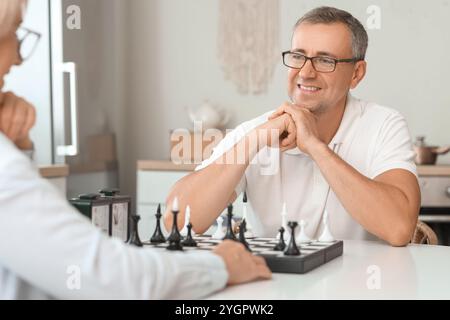 Seniorenpaar, das zu Hause gemeinsam Schach spielt Stockfoto