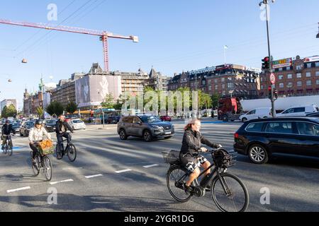 Männer und Frauen, die mit ihren Fahrrädern durch das Stadtzentrum von Kopenhagen fahren, auf einem speziellen Radweg neben Kraftfahrzeugen Stockfoto