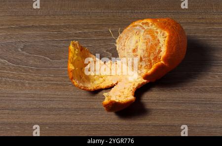 Nahaufnahme einer halbgeschälten Mandarinenfrucht. Stockfoto