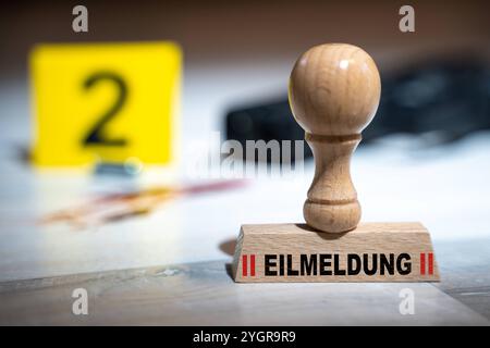 Bayern, Deutschland - 7. November 2024: DRINGENDE NACHRICHT, geschrieben auf einer Briefmarke an einem Tatort neben Blutspuren und einer Waffe. Symbolisches Bild für blutige Verbrechen und Polizeioperationen. PHOTOMONTAGE *** EILMELDUNG, stehen auf einem Stempel an einem Tatort neben Blutspuren und Pistole. Symbolbild für blutige Verbrechen und Einsätze der Polizei, bzw. Polizeieinsatz. FOTOMONTAGE Stockfoto