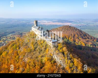 Die atemberaubende mittelalterliche Burg Bezdez wird von oben präsentiert, umgeben von lebhaftem Herbstlaub. Die Landschaft besticht durch sanfte Hügel und satte Farben, die typisch für die Saison sind. Stockfoto