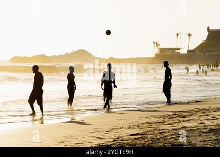 Salvador, Bahia, Brasilien - 6. Dezember 2019: Menschen werden bei Sonnenuntergang am Strand von Farol da Barra in Salvador, Bahia, beim Fußballspielen beobachtet. Stockfoto