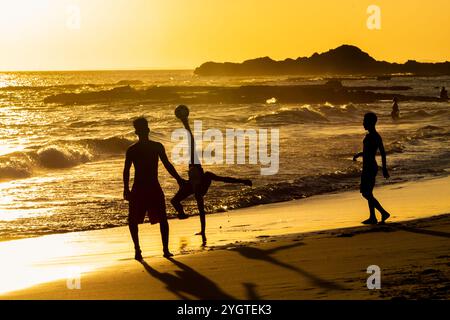 Salvador, Bahia, Brasilien - 6. Dezember 2019: Menschen werden bei Sonnenuntergang am Strand von Farol da Barra in Salvador, Bahia, beim Fußballspielen beobachtet. Stockfoto