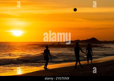 Salvador, Bahia, Brasilien - 6. Dezember 2019: Menschen werden bei Sonnenuntergang am Strand von Farol da Barra in Salvador, Bahia, beim Fußballspielen beobachtet. Stockfoto