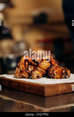 Nahaufnahme gegrillter Fleischrippchen auf einem Holzbrett, perfekt für eine herzhafte und geschmackvolle Mahlzeit Stockfoto