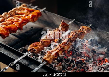 Saftige Grillspieße, die über heißer Holzkohle rösten, perfekt für Grillfreunde und Sommerversammlungen Stockfoto