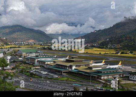 Flughafen Paro aus der Ferne mit dem Kloster Rinpung Dzong im Hintergrund. Stockfoto