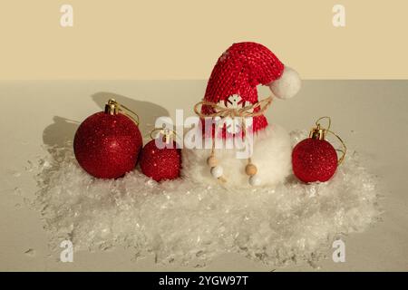 Rote Weihnachtskugeln auf falschem Schnee. Minimales Konzept der Unterhaltung für das neue Jahr. Stockfoto