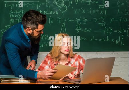 Lehrer, der seinen Schülern Mathematik oder Mathematik im Unterricht hilft. Zurück zur Schule. Der Lehrer unterrichtet einen Schüler. Konzept der Teamzusammenarbeit Stockfoto