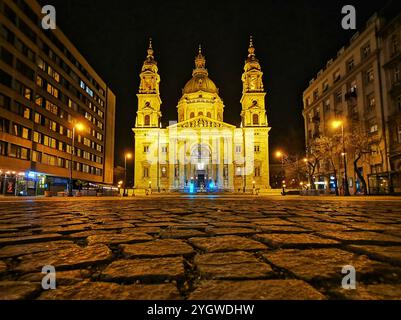 Im Herzen von Budapest steht die Stephansbasilika majestätisch beleuchtet am Nachthimmel. Seine majestätischen Kuppeln und seine komplizierte Architektur Stockfoto