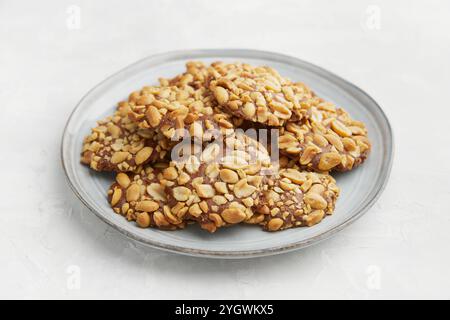 Ein Haufen traditioneller portugiesischer Erdnusskekse, bekannt als Bolachas de Amendoim auf der grauen Platte auf dem grauen Hintergrund Stockfoto