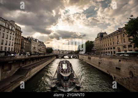 Bootsfahrt auf der seine unter dramatischem Himmel bei Sonnenuntergang - Paris, Frankreich Stockfoto