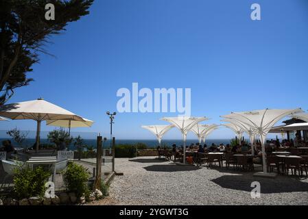 Malerisches Restaurant am Meer mit Sonnenschirmen in Cascais - Portugal Stockfoto