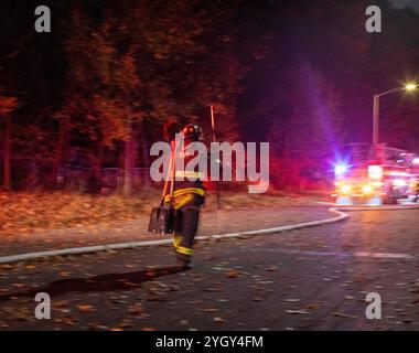 Ein Feuerwehrmann trägt Schaufeln, als er auf den Waldbrand am 8. November 2024 im Prospect Park, Brooklyn, NY, USA, reagiert Stockfoto