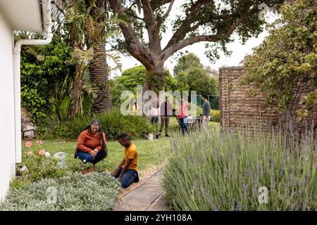 Gemeinsame Familie im Garten, die Zeit und Natur im Freien genießt Stockfoto