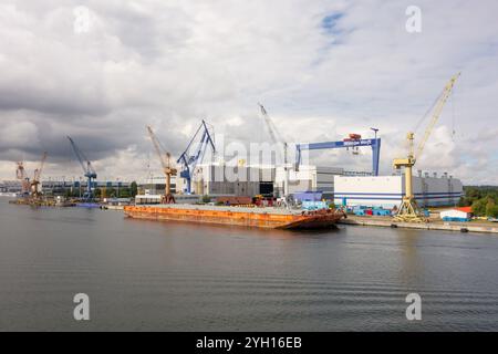 ROSTOCK, DEUTSCHLAND - 19. AUGUST 2016: Industriehafen in Rostock mit vielen Kränen, schweren Ausrüstungen und Schiffen. Stockfoto