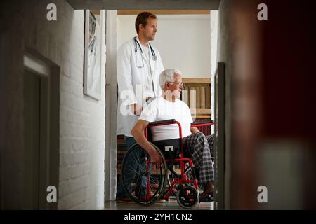 Arzt, älterer Mann und Rollstuhl am Fenster mit Reflexion, Gedächtnis und Denken mit Erholung. Arzt, Patient und Seniorin mit Behinderung Stockfoto