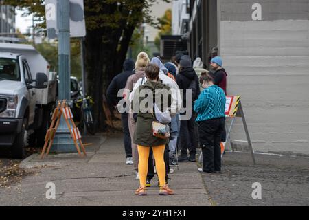 Die Wähler warten in der Warteschlange, um am Wahltag 2024 in die Multnomah County Elections Division einzutreten, eine Wählerregistrierungsstelle in Portland, Oregon. Stockfoto