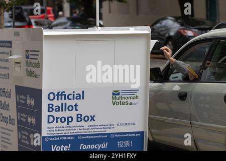 Die Wähler geben ihre Stimmzettel an einer Wahlbox vor der Multnomah County Wahlabteilung ab, einer Wählerregistrierungsstelle in Portland... Stockfoto